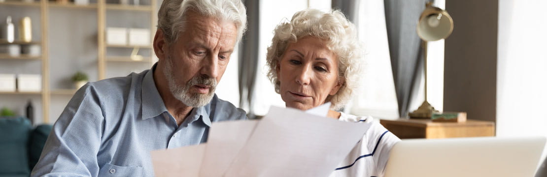 An elderly couple looking at documents.