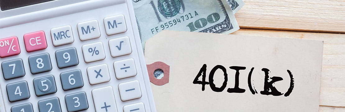 Close up of a calculator, US dollar bills and a tag that says "401(k)"